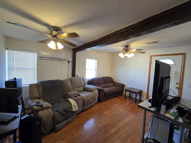 living room featuring beamed ceiling, hardwood / wood-style floors, a wall unit AC, and ceiling fan