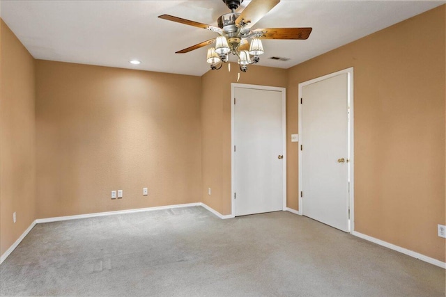 empty room featuring ceiling fan and light colored carpet