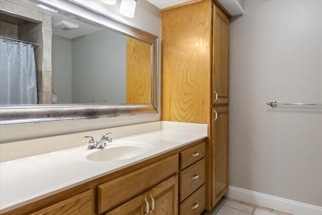 bathroom with tile patterned flooring, vanity, and walk in shower