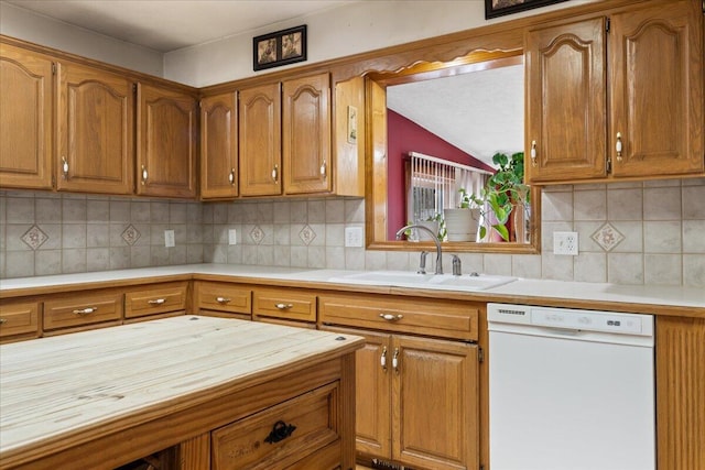 kitchen featuring backsplash, sink, and white dishwasher