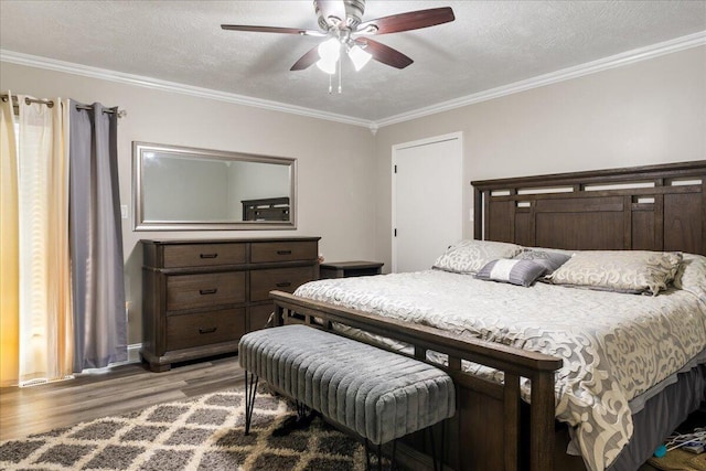 bedroom with ceiling fan, crown molding, light hardwood / wood-style floors, and a textured ceiling