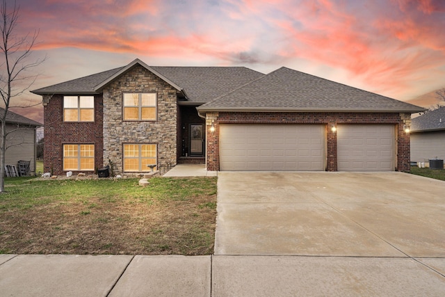 view of front of house featuring central AC, a yard, and a garage