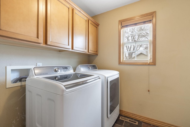 clothes washing area featuring cabinets and washing machine and dryer