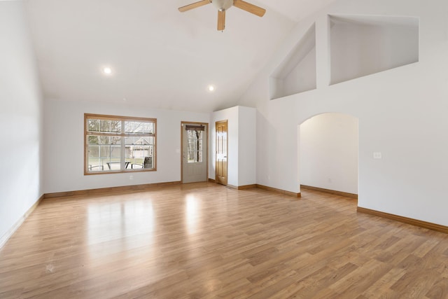 unfurnished living room with ceiling fan, light wood-type flooring, and high vaulted ceiling