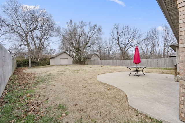 view of yard with a garage, an outdoor structure, and a patio