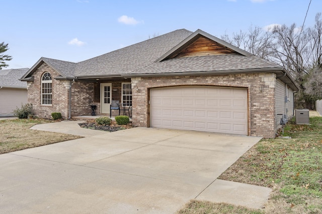 ranch-style home with a garage and central air condition unit