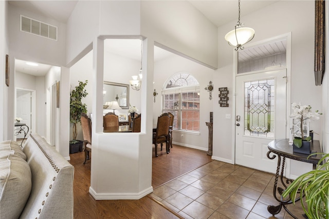 tiled foyer featuring a chandelier