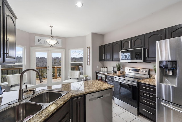 kitchen with french doors, hanging light fixtures, sink, appliances with stainless steel finishes, and light tile patterned flooring