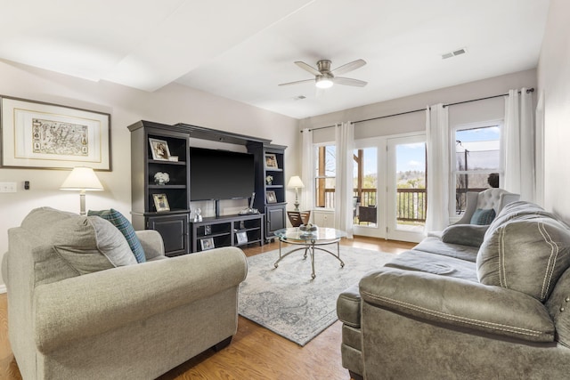 living room featuring ceiling fan, plenty of natural light, and hardwood / wood-style flooring