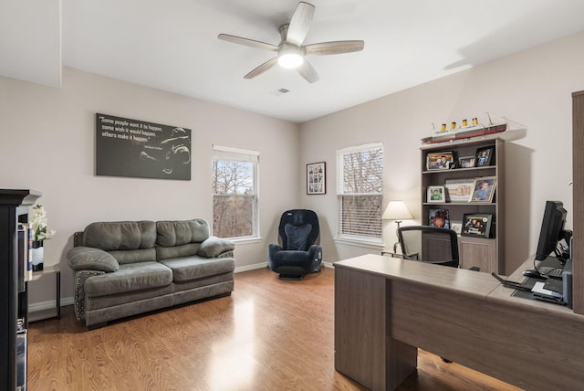 office with ceiling fan and light hardwood / wood-style flooring