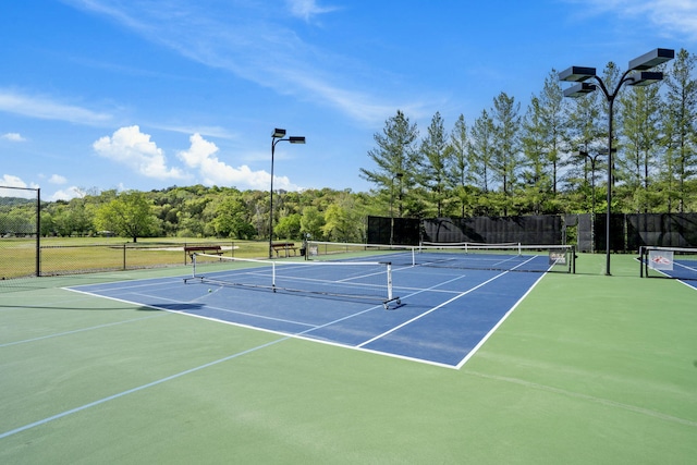 view of tennis court with basketball hoop