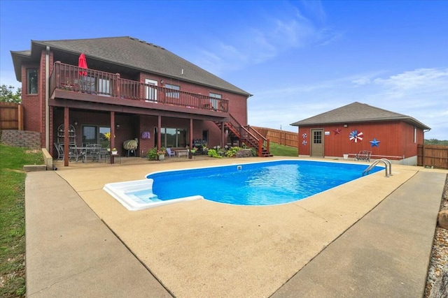 view of swimming pool with an outbuilding, a patio, and a wooden deck