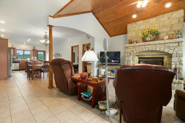 tiled living room with a notable chandelier, a stone fireplace, wood ceiling, and lofted ceiling