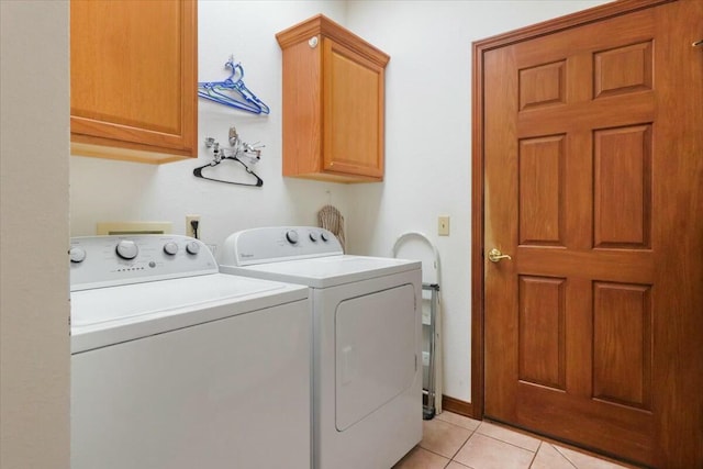 clothes washing area featuring light tile patterned flooring, cabinets, and independent washer and dryer