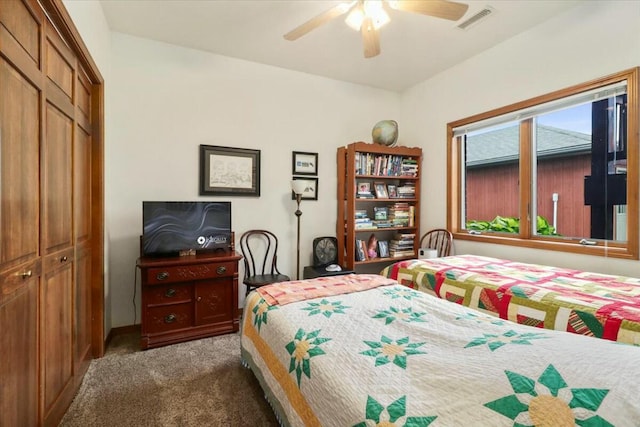 bedroom with ceiling fan, a closet, and dark carpet