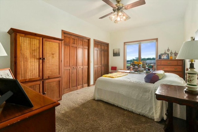 carpeted bedroom featuring two closets and ceiling fan