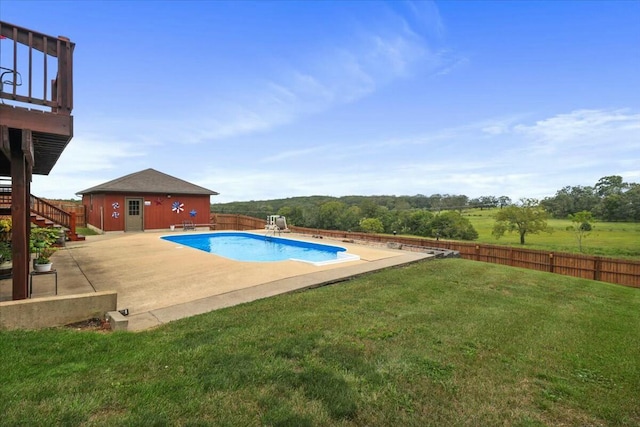 view of pool featuring a lawn, an outbuilding, and a patio