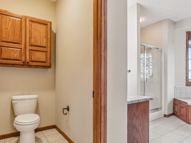 bathroom with tile patterned floors, vanity, a shower with shower door, and toilet