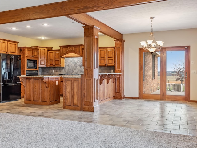 kitchen featuring a notable chandelier, a breakfast bar area, light carpet, a kitchen island, and black appliances