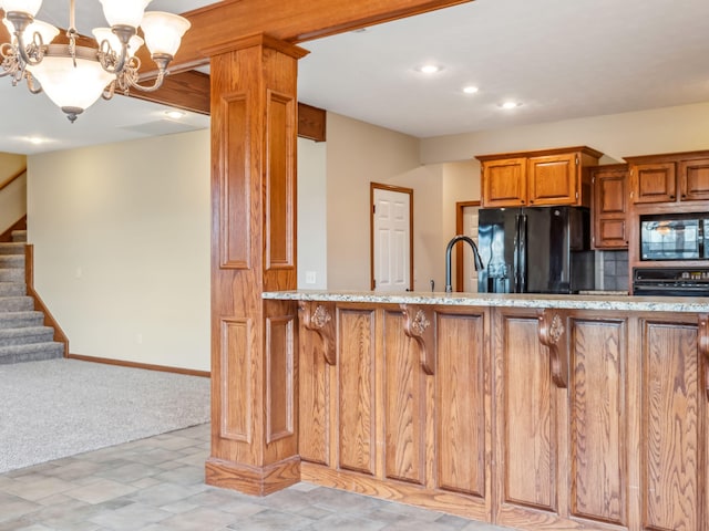 kitchen with tasteful backsplash, sink, black appliances, decorative light fixtures, and a notable chandelier