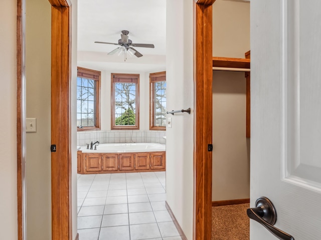 bathroom featuring tile patterned flooring, ceiling fan, and a bathing tub