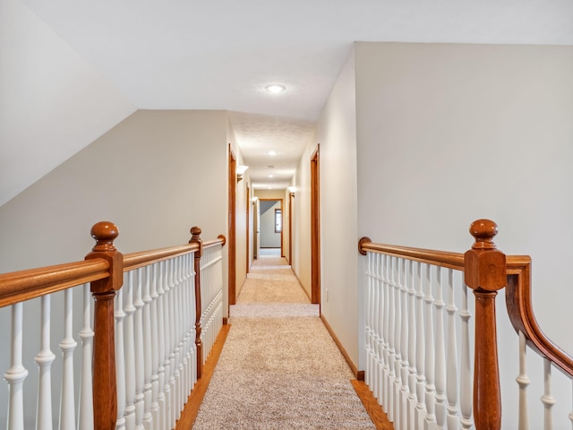 corridor with light colored carpet and lofted ceiling