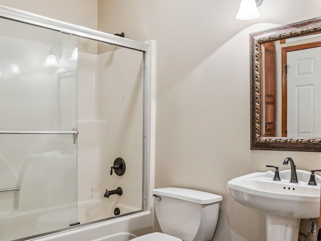 full bathroom with toilet, enclosed tub / shower combo, and sink