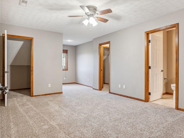 carpeted empty room featuring ceiling fan and a textured ceiling