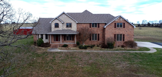 view of front of home with a porch and a front yard