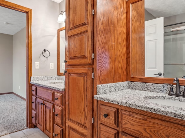 bathroom featuring tile patterned floors, vanity, and a textured ceiling