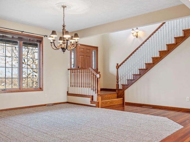 foyer featuring wood-type flooring and a notable chandelier