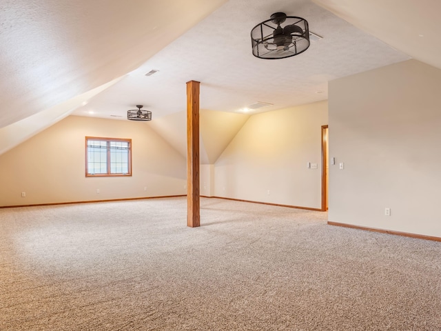 bonus room featuring carpet flooring, a textured ceiling, ceiling fan, and lofted ceiling