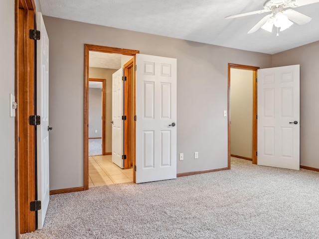 unfurnished bedroom featuring light colored carpet and ceiling fan