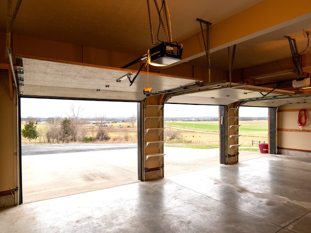 garage with a rural view and a garage door opener