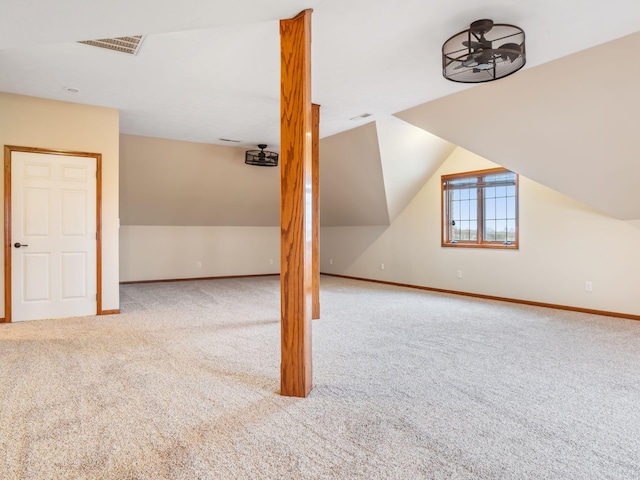 bonus room with lofted ceiling and light carpet