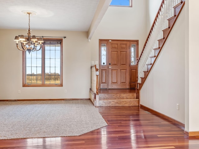 entrance foyer featuring dark hardwood / wood-style floors and an inviting chandelier