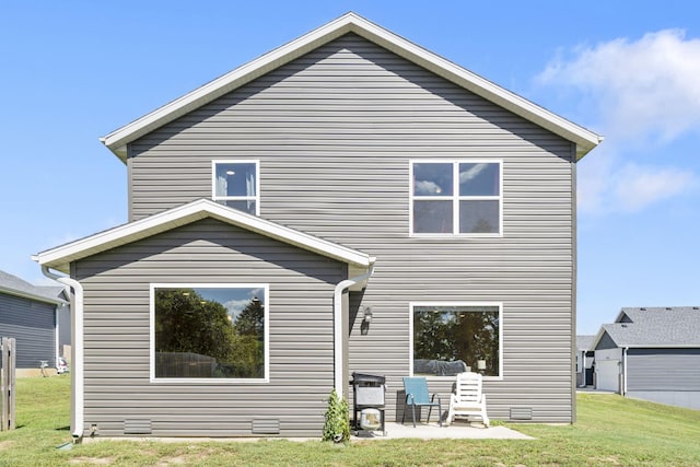 back of property with a lawn and a patio area