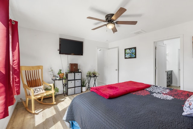 bedroom with ceiling fan, connected bathroom, and light hardwood / wood-style flooring