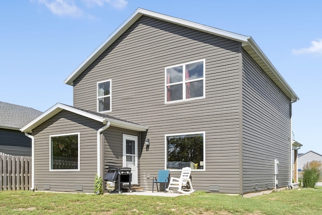 back of property featuring a lawn and a patio area