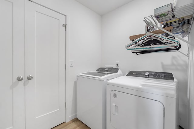 laundry room with washer and dryer and light hardwood / wood-style floors