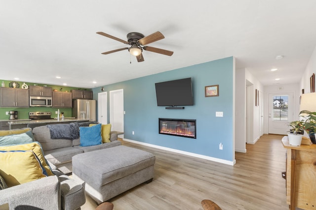 living room featuring ceiling fan and light hardwood / wood-style floors