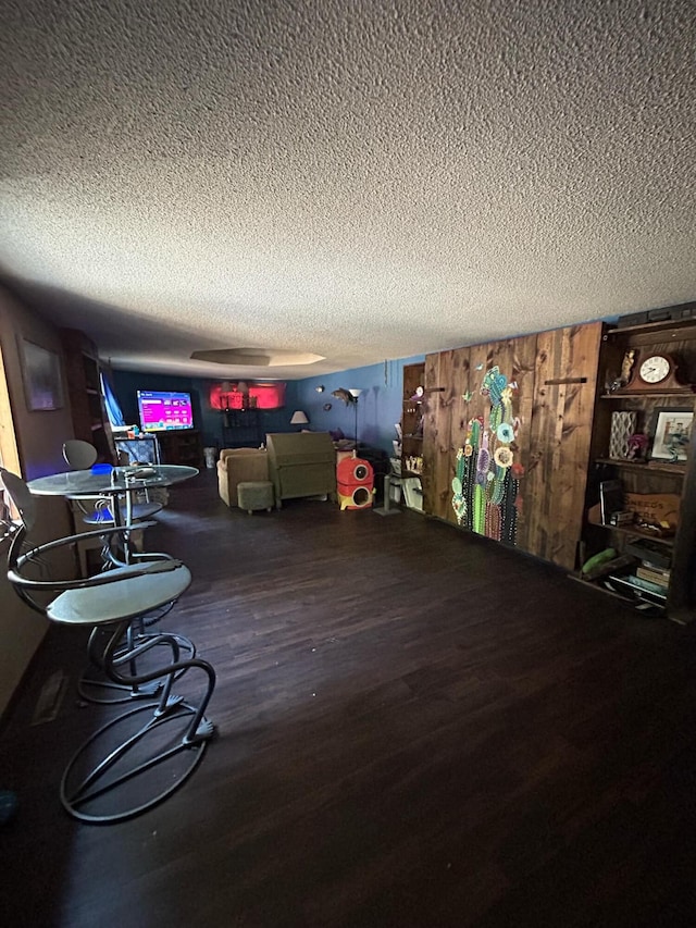 bedroom with hardwood / wood-style floors, a textured ceiling, and pool table