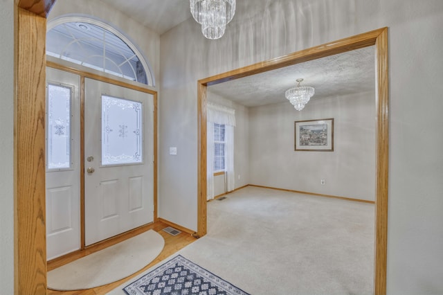 foyer featuring a chandelier and a textured ceiling