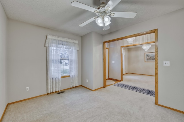 carpeted empty room with ceiling fan and a textured ceiling