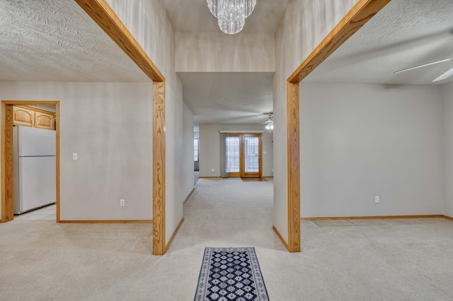 foyer entrance featuring french doors, light colored carpet, and ceiling fan with notable chandelier