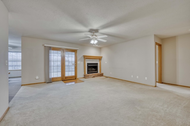 unfurnished living room with a textured ceiling, ceiling fan, light carpet, and a brick fireplace