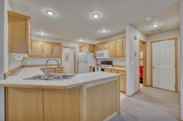 kitchen featuring kitchen peninsula, white appliances, a textured ceiling, sink, and light brown cabinets