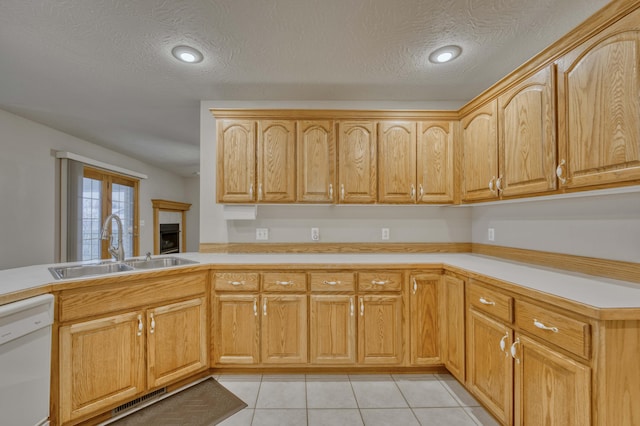 kitchen with sink, kitchen peninsula, white dishwasher, light brown cabinetry, and light tile patterned floors