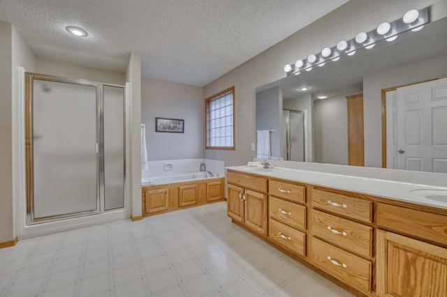 bathroom featuring vanity, a textured ceiling, and separate shower and tub