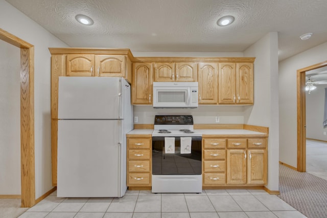 kitchen with light brown cabinetry, white appliances, a textured ceiling, ceiling fan, and light tile patterned flooring